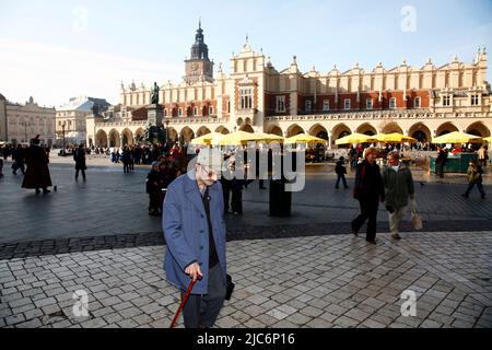 Nov 9, 2011. Old man is passing the Main Market Square in front of the Sukiennice. (CTK Photo/Grzegorz Klatka) Stock Photo