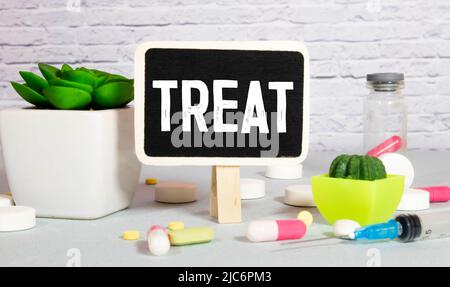 Treat word written on wooden blocks and stethoscope on light blue background. Healthcare conceptual for hospital, clinic and medical busines. Stock Photo