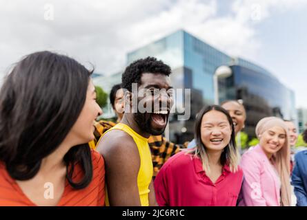 Young multiracial friends having fun together hanging out in the city - Friendship and diversity concept Stock Photo