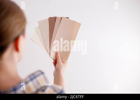 Young woman holds in her hand color paint samples for the wall Stock Photo
