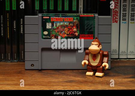 A Donkey Kong Toy posed beside Donkey Kong Country Video Game (NC State, 2022) Stock Photo