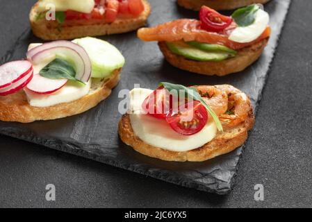 bruschetta Italian appetizer. Italian appetizer on a dark background. Sandwich Set. Stock Photo