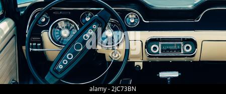Retro styled image of an old classic sports car dashboard with black and white interiors. Stock Photo