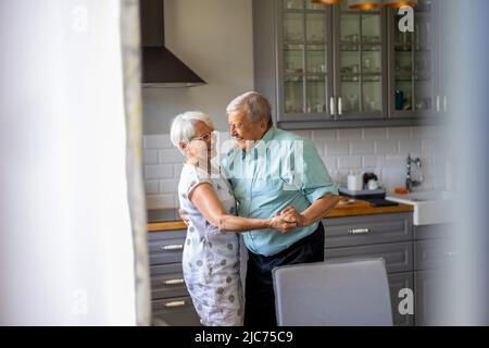 Senior Couple Dancing in their Kitchen Stock Photo