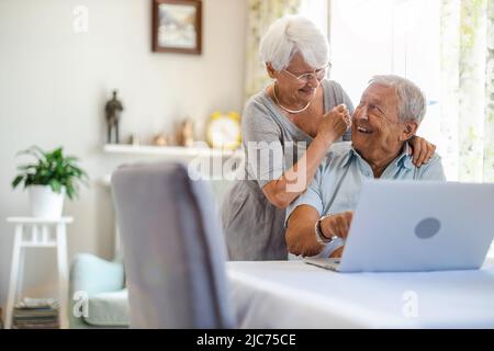 Happy senior couple using laptop at home Stock Photo