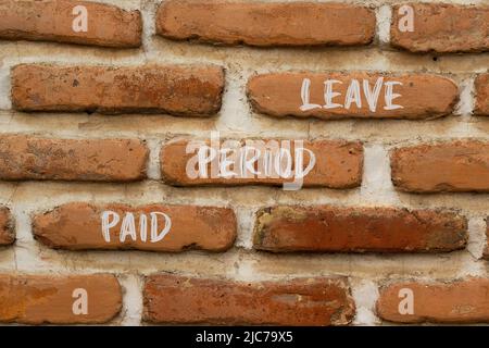 Paid period leave symbol. Concept words Paid period leave on brick wall. Beautiful brick wall background. Business medical paid period leave concept. Stock Photo