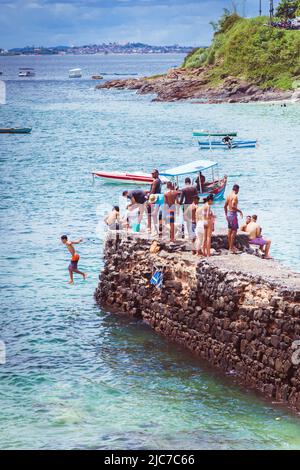 Kids jumping from the Pier of Barra Beach on a beautiful day, salvador de bahia, brazil. Stock Photo