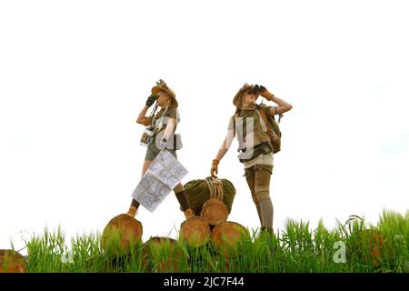 Two young girls dress up as explorers.They pose in a rocky outdoor