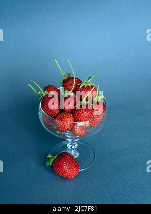 Glass bowl with fresh strawberries isolated on soft blue  background Stock Photo