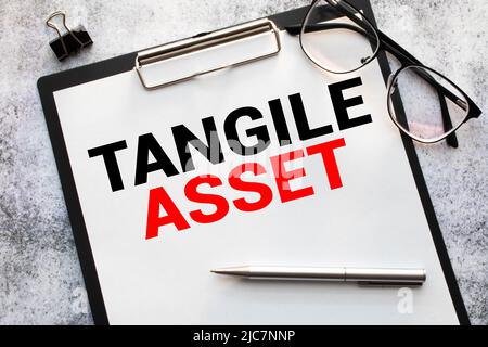 Tangible Asset text written on a notebook with pencils. Stock Photo