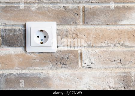 white double socket is built into the brick wall. Stock Photo