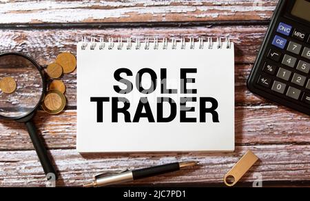 Closeup on businessman holding a card with text SOLE TRADER, business concept image with soft focus background and vintage tone. Stock Photo