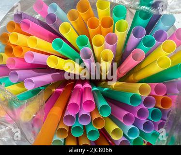 Multi-colored straws in a plastic bag, color of the straws are yellow, green, pink, blue, purple, orange Stock Photo