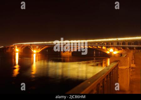 Street lights on bridge reflected in river at night Stock Photo