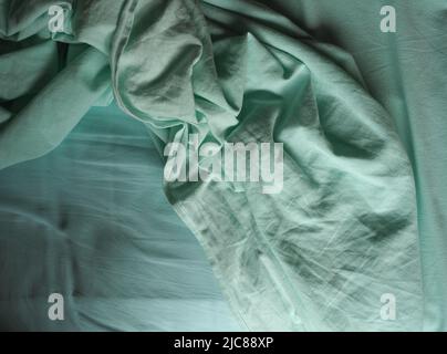crumpled teal green fabric texture useful as a background Stock Photo