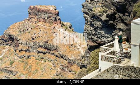 A man looking out from his terrace to Skaros Rock outside Imerovigli on Santorini island Stock Photo