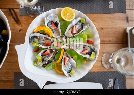 Beautiful arranged fresh Oysters on ice and with fruit decoration Stock Photo