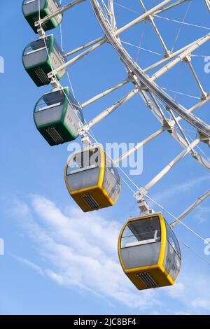 Closeup of multicolored Tempozan Ferris Wheel in amusement park with blue sky in Tbilisi, Georgia Stock Photo