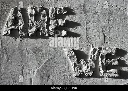 Rough inscription on the plastered gray wall. We are. Bas-relief. Stock Photo
