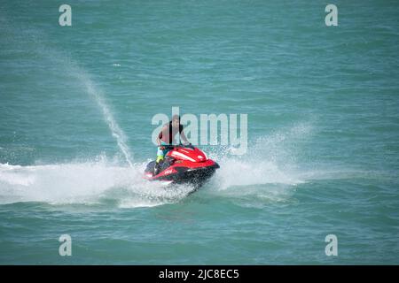 A young Indian male driving a jet ski in the Arabian Gulf, Kuwait City Stock Photo