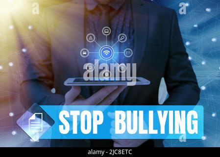 Hand writing sign Stop Bullying. Business approach Fight and Eliminate this Aggressive Unacceptable Behavior Man holding Screen Of Mobile Phone Stock Photo
