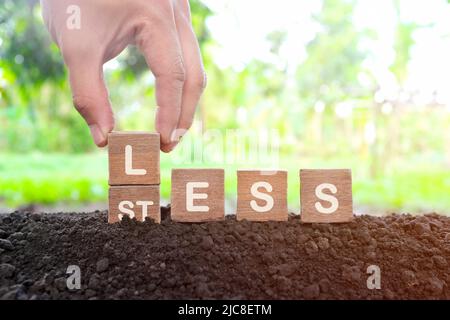 Less stress management concept. Hand changing stress to less word on wooden blocks. Stock Photo