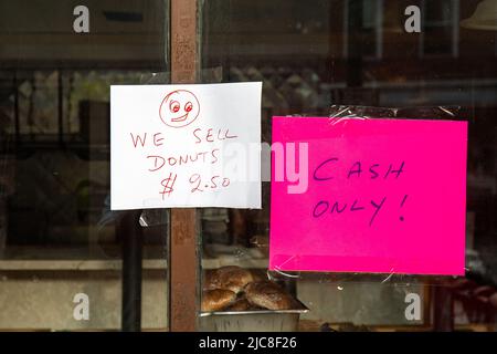 We Sell Donuts. Paper note on bakery window in Meat Packing District, New York City, United States of America. Stock Photo