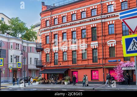 MOSCOW, RUSSIA - June 11, 2022, People sit in a street cafe under a red brick house on Malaya Bronnaya street, house 28. Patriarch's Ponds area Stock Photo