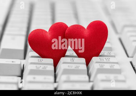 Small red hearts on keyboard. Internet dating concept. Stock Photo