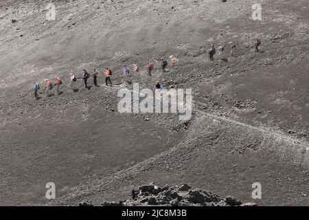 Trekking of hikers and tourists who walk to the Etna volcano crater -Sicily Stock Photo