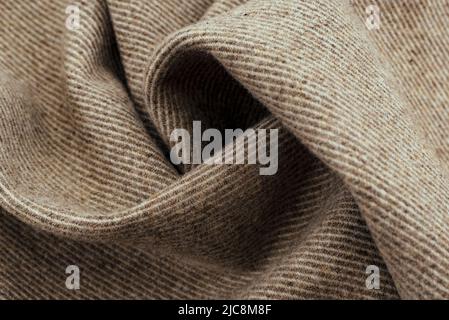 Texture of twisted dense material of brown color. Piece of fabric with waves for tailoring Stock Photo