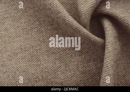Texture of twisted dense material of brown color. Piece of fabric with waves for tailoring Stock Photo