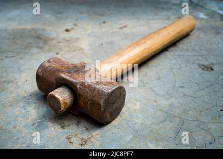 A bulky vintage cast iron hammer with natural wooden handle. uttarakhand India Stock Photo