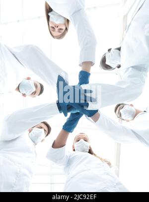 Doctors and nurses in a medical team stacking hands Stock Photo