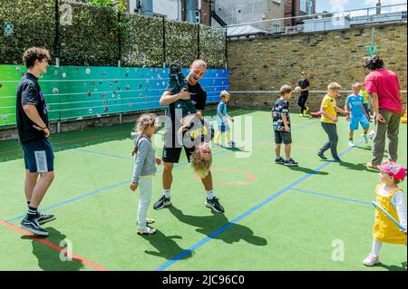 London, UK. 11th June, 2022. Volunteers play with the kids - Familes4Peace welcomes Ukrainian mums and children from across NW London to The Cavendish School in Camden. Speakers provide practical information on access to services, relocation advice and jobs while children play helped by volunteers. They benefit from coming together with others in the same predicament, hopefully helping to reduce the trauma of moving to a new country while leaving family members behind to face uncertainty and danger. ‘London stands with Ukraine'. Credit: Guy Bell/Alamy Live News Stock Photo