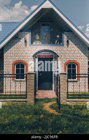 Facade of an unfinished two-story house with no red brick windows