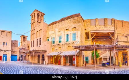 Panorama of the scenic vintage adobe houses with windcatchers and tourist shops, located in Al Seef, Dubai, UAE Stock Photo
