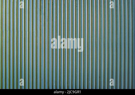 fence made of strips of gray aluminum pipes. Vertical parallel lines. Abstract texture background. Stock Photo