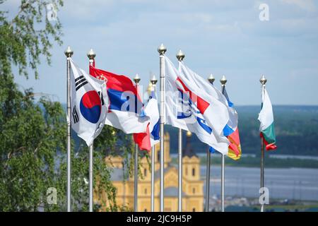 Various street flags of different countries develop on the flagpole.National symbols. Stock Photo