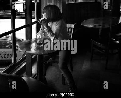 A woman enjoys a pint of beer  at Vesuvio Cafe, a landmark bar in San Francisco, California, frequented by members of the 1950s Beat Generation. Stock Photo