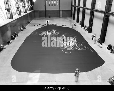 London, Greater London, England, June 08 2022: Monochrome. Interior of Tate Modern with a live exhibition watched by visitors. Stock Photo
