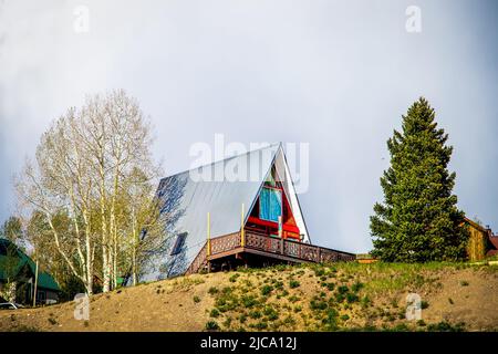 Aframe house on top of hill with aspen and evergreen trees in ski resort village in Colorado USA Stock Photo