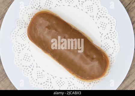 Overhead view of tempting fresh from the oven maple bar donut from the bakery served on a plate. Stock Photo
