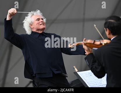 EDITORIAL USE ONLY Sir Simon Rattle conducts the London Symphony Orchestra with young musicians from the LSO On Track programme as they perform a new composition titled FAIYA!, at the BMW Classic 2022 LSO Concert in Trafalgar Square London. Picture date: Saturday June 11, 2022. Stock Photo