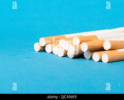 image of tobacco cigarette filters on blue background. Concept of health Stock Photo