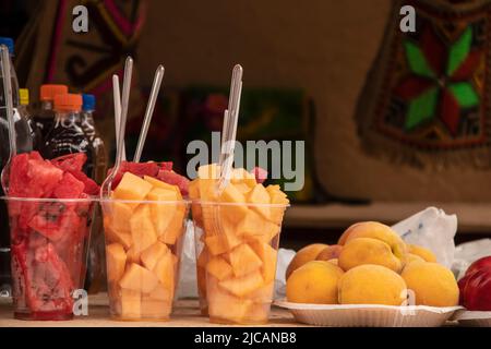 Plastic containers of fruit and plates of lemons for sale at a roadside stand in eastern Europe with hanging blurred behind Stock Photo