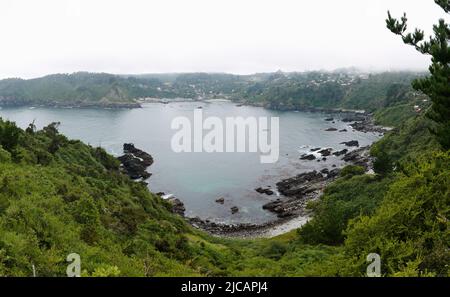 Panorama of bay on Pacific coast of Chile from coastal cliffs of Bahia Mansa village, San Juan de la Costa, Los Lagos. Bay surrounded by rocky hills Stock Photo