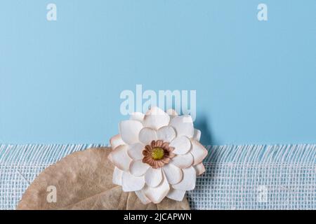 single paper flower bottom border with fringed white burlap and dry leaves Stock Photo