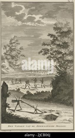 Landscape with Khoikhoi hunting moles, digging holes in the ground In the foreground a hole above which hangs from a cross a tuber that an African mole has come to hunt When the animal eats the tuber a rope construction ensures that the gun goes off and the mole is shot, Khoikhoi hunting moles Catching the African Moles , print maker: Jan Caspar Philips, Jan Caspar Philips, (mentioned on object), Amsterdam, 1727, paper, etching, engraving, h 295 mm × w 173 mm Stock Photo