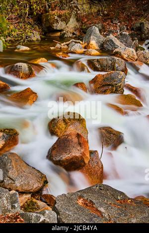 Rocks in river with water cascading over Stock Photo